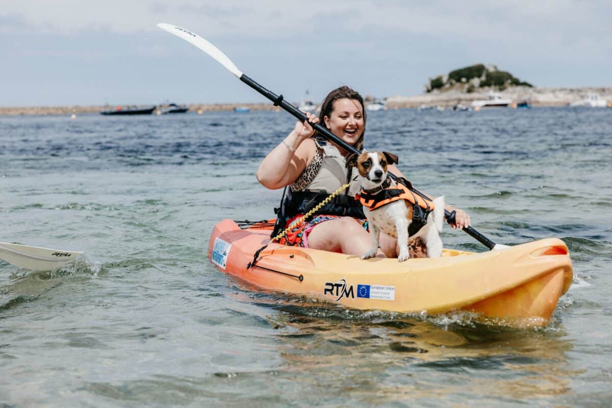 woman and dog in a kayak on a summer holiday in scilly